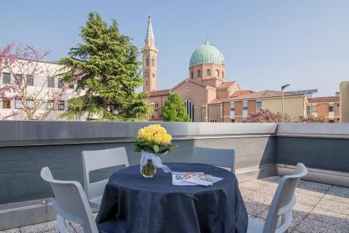 a table with a vase of flowers on a balcony at Casa Lucia Valentini Terrani in Padova
