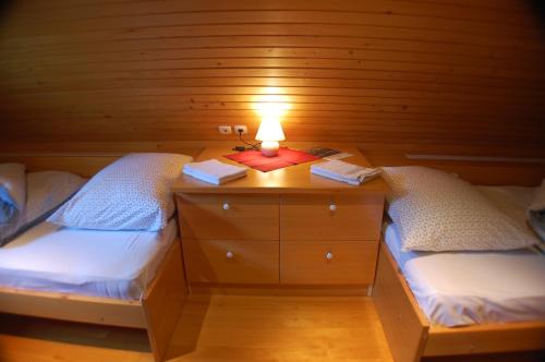 a room with two beds and a light on a table at Chalet ApArt Kupljenik 12 A, Bled in Bohinjska Bela