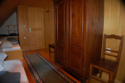 a living room with a wooden cabinet and a chair at Chalet ApArt Kupljenik 12 A, Bled in Bohinjska Bela