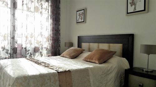 1 dormitorio con 1 cama con 2 almohadas en Benidorm Gemelos penthouse with private pool, en Benidorm