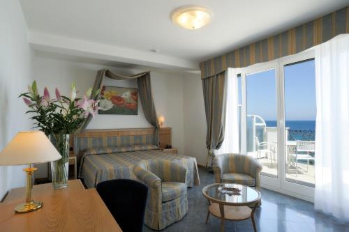 Habitación de hotel con cama y balcón con vistas al océano. en Grand Hotel Mediterranee, en Alassio