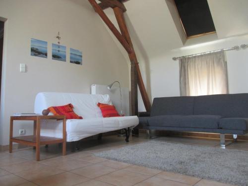 a living room with a white couch and a table at Gîte L'air pur in Roisin
