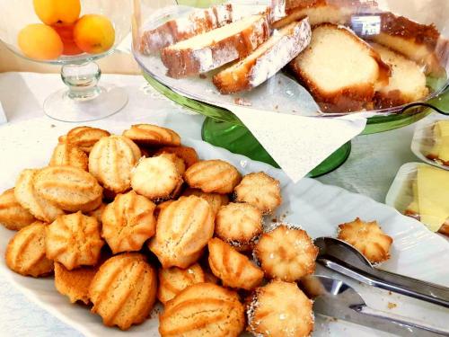 a plate of food on a table with bread and desserts at Lucky Hotel in Veliko Tŭrnovo
