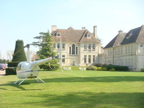 a helicopter sitting on the grass in front of a house at Brockencote Hall in Kidderminster