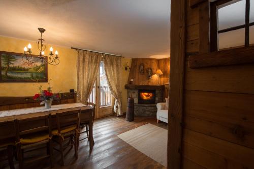 a dining room with a table and a fireplace at Bellavista Cogne Apartment in Cogne