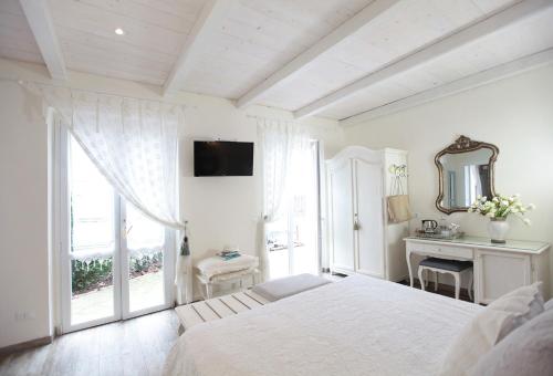 a white bedroom with a bed and a window at Villa Valentina in Levanto