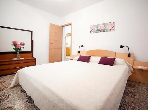1 dormitorio con 1 cama blanca grande con almohadas moradas en Villa Caleta 0901, en Calpe
