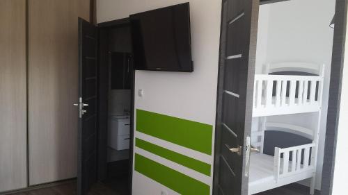 a bathroom with a toilet and a tv on the wall at Flaming - domki letniskowe in Rowy