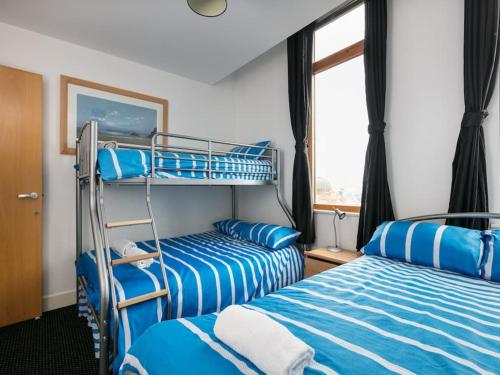 マンチェスターにあるCity Centre Apartment With Panoramic Viewのベッドルーム1室(二段ベッド2台、窓付)が備わります。