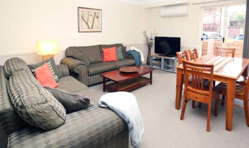 a living room with a couch and a table at Caulta Apartments in Sydney