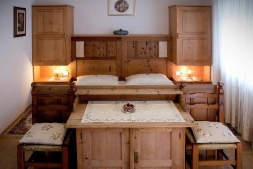 Habitación con 2 camas, mesa y 2 taburetes en Berggasthof Stern, en Predoi