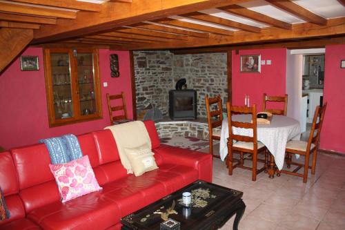 a living room with a red couch and a table at Normandy Nature Paradise in Vire