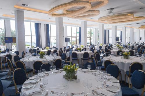 a banquet hall with white tables and chairs at Makedonia Palace in Thessaloniki