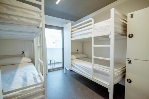 Letto o letti a castello in una camera di Amistat Island Hostel Ibiza - ALBERGUE JUVENIL
