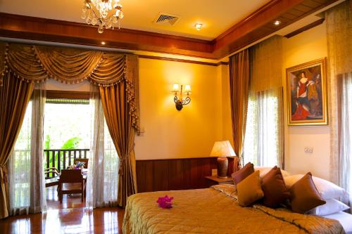 1 dormitorio con 1 cama grande y paredes amarillas en Oriental Siam Resort - SHA Extra Plus Certified, en Chiang Mai