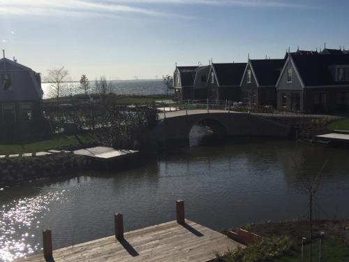 a bridge over a body of water with houses at Luxurious Water Villa in Uitdam