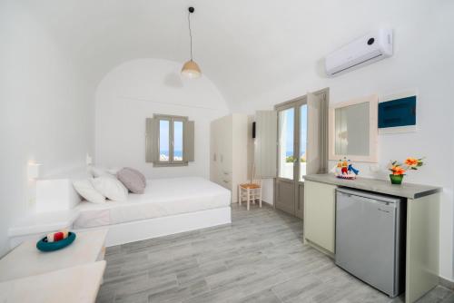 カマリにあるCasa Iphigeniaの白いソファとキッチンが備わる白いアパートメントです。