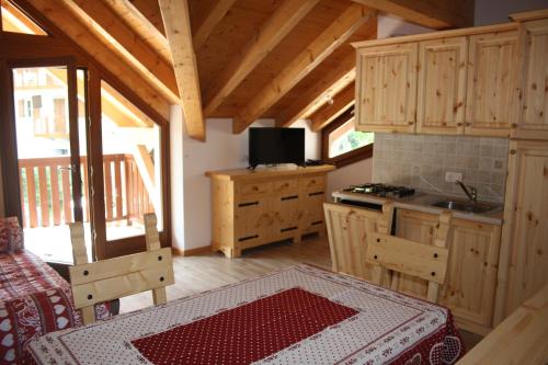 a kitchen with wooden cabinets and a table in a cabin at Appartamenti Ruby in Molveno