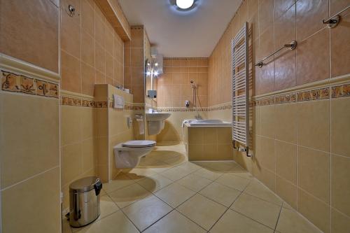 W łazience znajduje się toaleta, wanna i umywalka. w obiekcie Hotel Šariš w Bardejowie