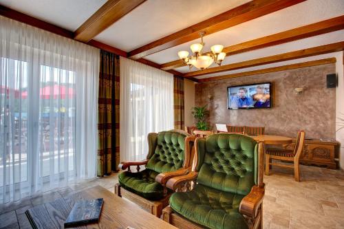 a living room with two chairs and a table at Hotel Alex in Sankt Kanzian