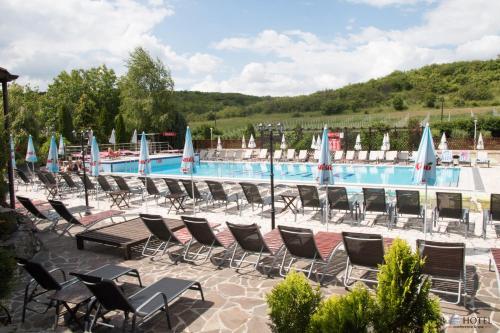 a large swimming pool with chairs and umbrellas at Silver Hotel in Oradea