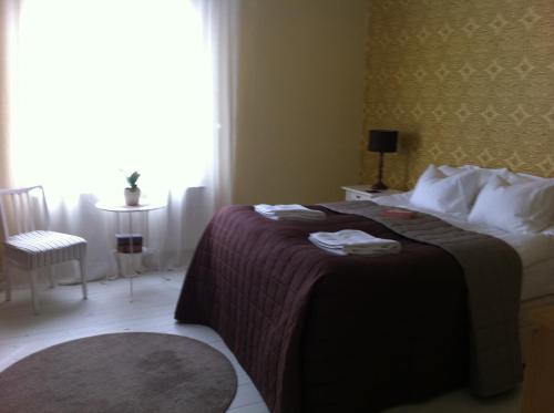 a hotel room with a bed with a window and a table at Gran Hotellihuoneistot 1 in Suolahti