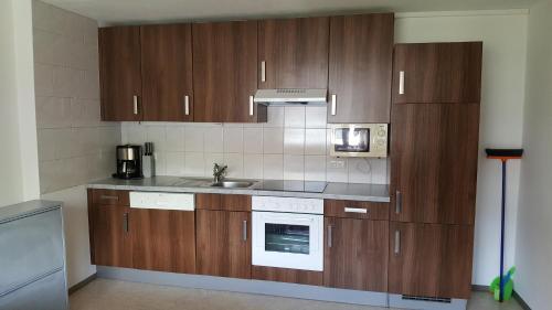 a kitchen with wooden cabinets and a sink at Gästehaus Bischof in Damuls