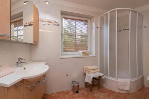 biała łazienka z umywalką i prysznicem w obiekcie Haus Elisengrund am Geigenbuehel - chalet privé w mieście Seefeld in Tirol