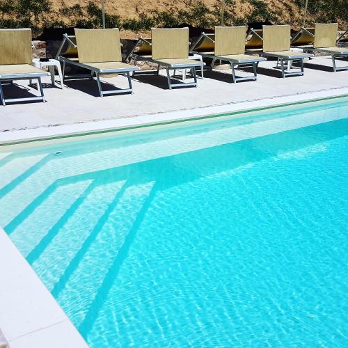 a swimming pool with chaise lounge chairs next to it at Residenza Eden in Colà di Lazise