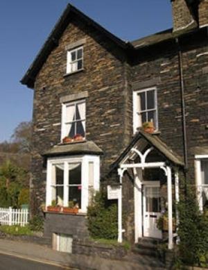 a brick house with a white door and windows at Lyndale Guest House in Ambleside