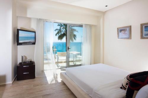a bedroom with a bed and a view of the ocean at Elite City Resort in Kalamata