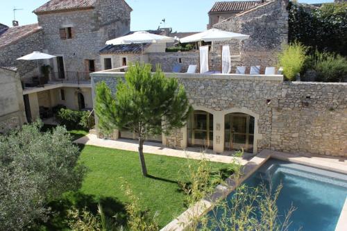 uma vista exterior de uma casa com piscina em Le Village em Vallérargues