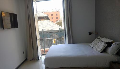 a bedroom with a bed and a large window at The Lights City Rooms in Málaga