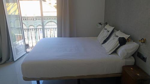 a bed in a room with a large window at The Lights City Rooms in Málaga