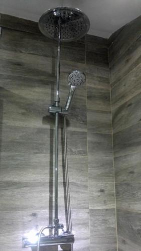 a shower in a bathroom with a tile floor at The Lights City Rooms in Málaga