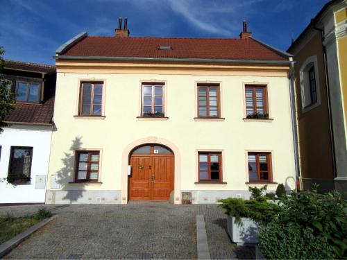 a large white house with a wooden door at Apartmán U Kostela in Veselí nad Moravou