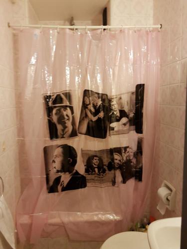 a shower curtain with pictures of people on it in a bathroom at Tango Cozy Estudio in Buenos Aires