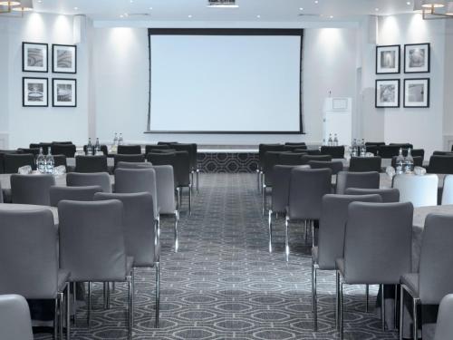 a conference room with chairs and a projection screen at Staverton Park Hotel & Golf Club in Daventry