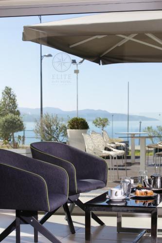 a patio with chairs and a table with food on it at Elite City Resort in Kalamata