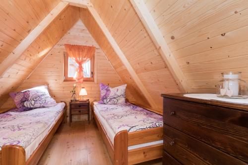 a bedroom with two beds in a log cabin at Domki Diament in Pobierowo