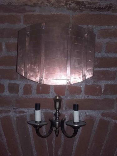 a light hanging on a brick wall with two candles at Réka Vendéghàz in Tokaj