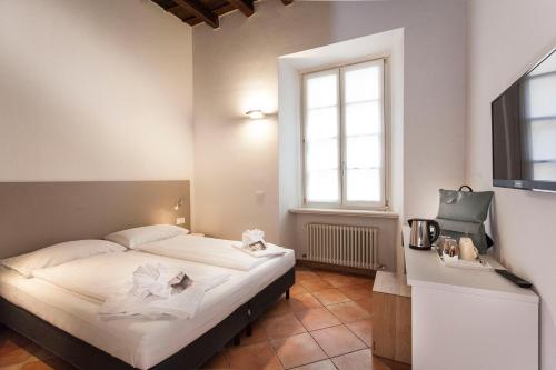 a bedroom with a bed with white sheets and a window at Casa Alla Lega in Arco