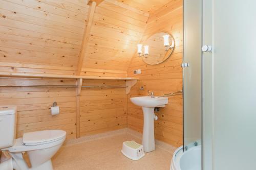 a wooden bathroom with a toilet and a sink at Domki Diament in Pobierowo
