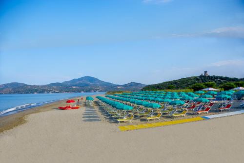 a beach with lounge chairs and umbrellas and the ocean at Villa Laura Residence Hotel Apartments & Studios in Ascea