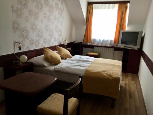 a hotel room with a bed and a television at Hotel Gloria Budapest City Center in Budapest