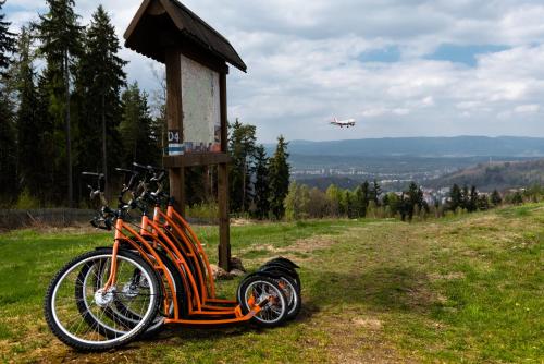 an orange bike parked next to a sign with an airplane at CAMP VARY - Vítkova Hora in Karlovy Vary