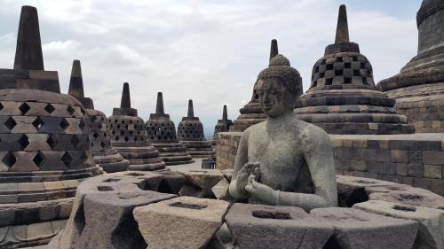 a statue sitting in front of a bunch of stupas at Sarasvati Borobudur in Borobudur