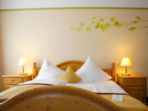 a bedroom with a bed with white sheets and two lamps at Hotel Speeter in Weisenheim am Berg