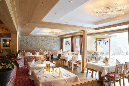 uma sala de jantar com mesas e cadeiras brancas em Hotel Schwarzwald-Gasthof Rößle em Todtmoos