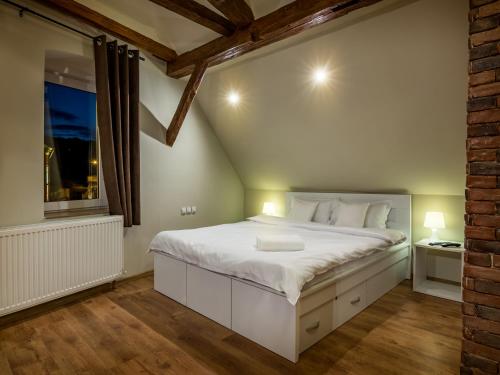 a bedroom with a white bed and a window at Studio Unseen Brasov in Braşov